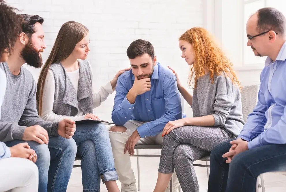 Gruppe von Menschen in Therapie eines psychisch kranken Menschen
